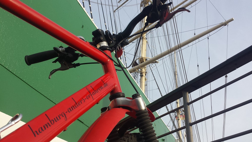 Rotes Mountain Bike vor grünem Schiffsrumpf (Rickmar Rickmers)
