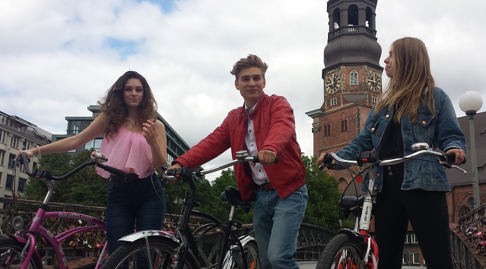 Hamburgs cooler Fahrrad Verleih: Hier 3 junge Fahrradfahrer vor der St. Katharinenkirche mit Beach Cruisern