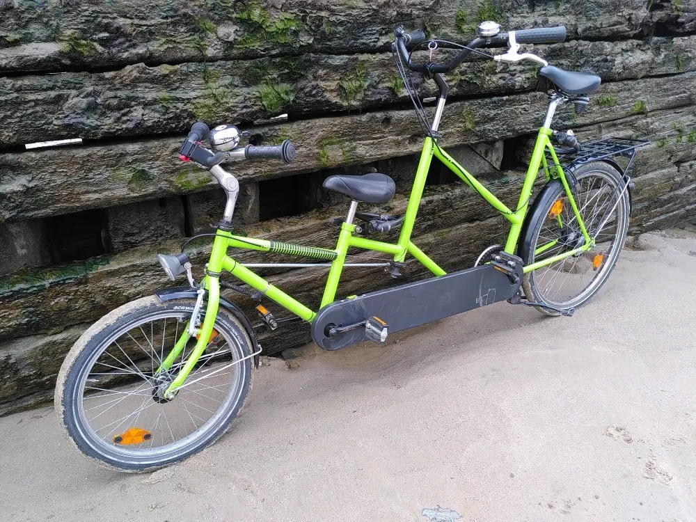 Eltern Kind Tandem vor vermooster Plankenwand eines Schiffswracks