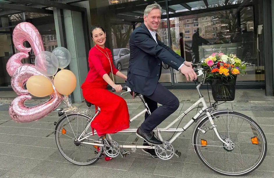 Glückliches Hochzeitspaar auf weißem Tandem!