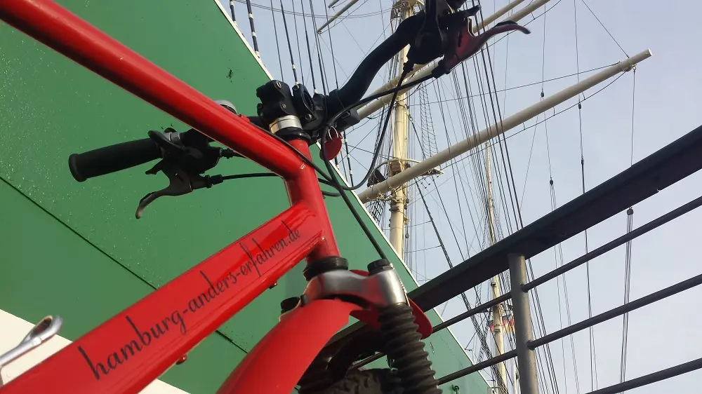 Mountain Bike Rental in Hamburg, rotes Mounty vor grünem Segelschiff