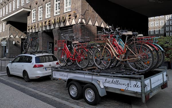 Fahrradtransport mit E-Bikes, Tandems, Kinderrädern, City Bikes, Trekking Bikes u.a. Im Hintergrund der Sprinkenhof
