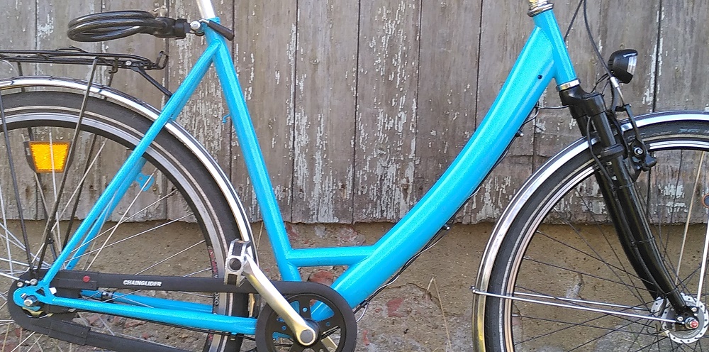 Hellblaues Cityrad vor grauem Holzschuppen